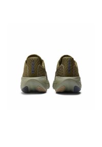 Zapatillas deportivas verdes con parte superior texturizada, tacones redondeados y colores de suela contrastantes. Presenta una marca en la parte trasera y un collar acolchado.