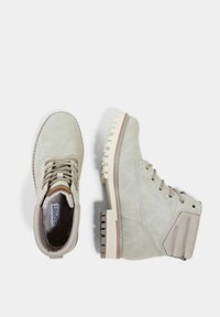 Stivali alla caviglia beige in morbido suede, con design allacciato, suola in gomma e pannello laterale testurizzato con doppi accenti.