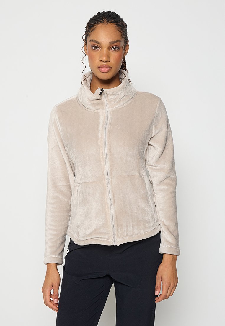 Fleecejacke in hellem Beige mit hohem Kragen, Reißverschluss vorne und zwei vorderen Taschen. Der Stoff hat eine weiche, strukturierte Oberfläche.