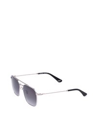 Lunettes de soleil à monture métallique fine avec verres dégradés noirs et branches courbées noires sur fond blanc.