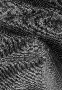 Donkergrijze denimstof met een gestructureerd oppervlak, waarin een subtiel weefpatroon en een soepele val zichtbaar zijn.