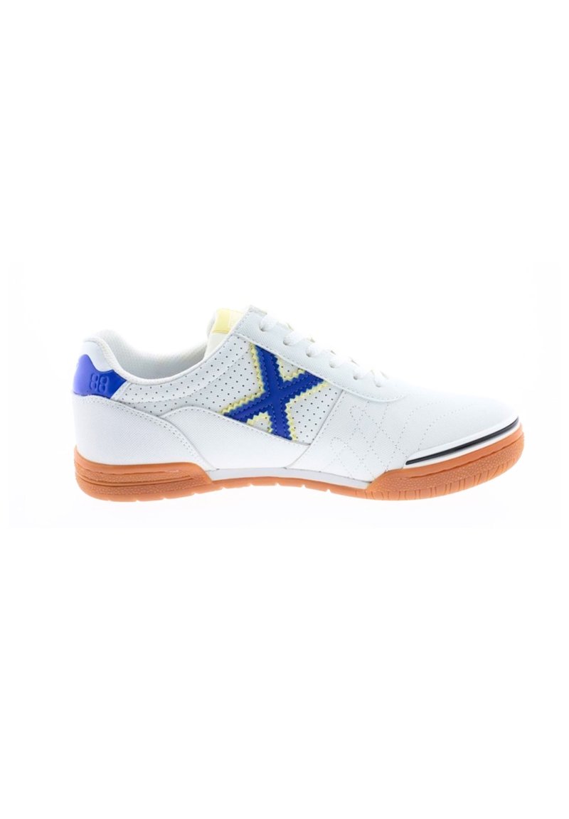 Zapatilla deportiva blanca con un diseño perforado, acento azul en forma de X, suela de goma naranja y raya negra en la puntera.