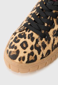 Sneaker con stampa leopardata caratterizzata da una parte superiore testurizzata in beige e nero, lacci neri e suola in gomma con un motivo rigato.