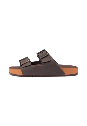 Brown slide sandal with two adjustable buckled straps and a contrasting tan cushioned sole on a white background.