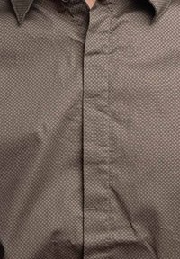 Camicia marrone a bottoni con un sottile motivo a nido d'ape, realizzata in un tessuto liscio, con colletto classico e dettagli della pattina frontale.