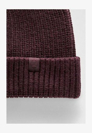 Cappello di lana a coste di un profondo colore viola, con risvolto e piccolo etichetta in tessuto che presenta un logo circolare in rilievo.