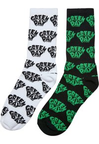 Fekete-fehér crew zoknik, amelyek ismétlődő "Green Day" logóval és grafikus kezekkel díszítettek, pamutból készültek, puha, kötött textúrával.