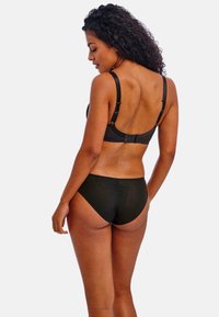 Black bra and matching bikini bottom displayed from the back. Bra features adjustable straps and hook closure, fabric appears smooth and stretchy.