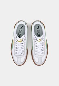 Sneaker bianche con accenti verdi, realizzate in pelle testurizzata e materiale sintetico, dotate di chiusura con lacci e suola in gomma marrone.