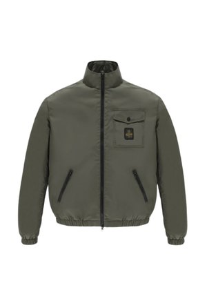 Giacca verde oliva con zip, colletto rialzato, polsini ed orlo elasticizzati, due tasche laterali con zip e una tasca sul petto con bottone e toppa con logo.