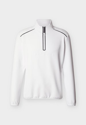 Valkoinen pitkähihainen pusero, jossa on neljänneksen vetoketju, mustat pipot olkapäillä, joustavat resorit hihansuissa ja helmassa sekä kohokuvioitu Calvin Kleinin logo edessä.