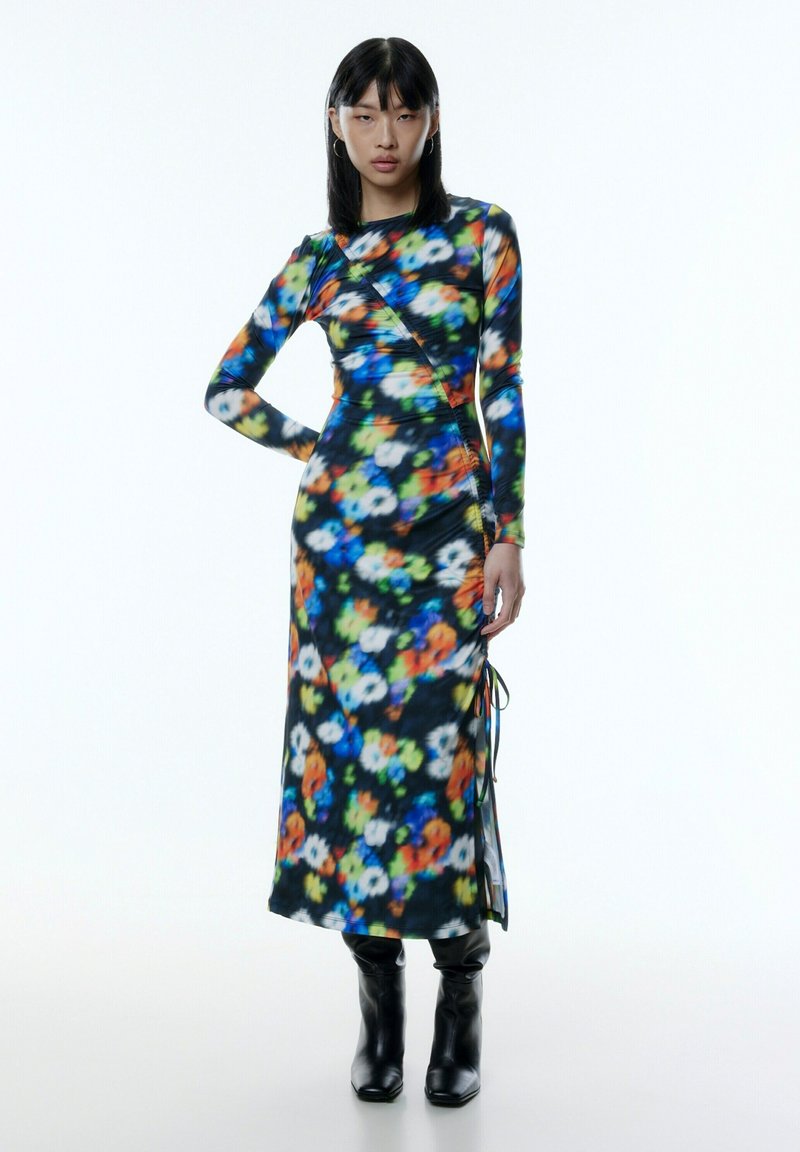 Langärmliges Blumen-Kleid aus dehnbarem schwarzem Stoff, mit einem bunten abstrakten Muster, seitlichen Bändern und einer taillierten Silhouette.