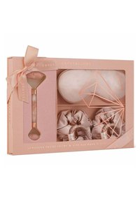 Jadeitowy rolka do twarzy, jedwabna maska na oczy i scrunchies zapakowane w jasnoróżowe pudełko z wstążką, ozdobione geometrycznymi akcentami w kolorze różowego złota.