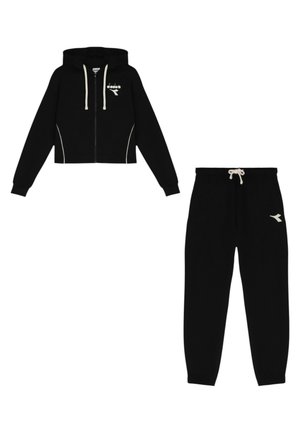 Felpa nera corta con zip e dettagli bianchi, con logo, abbinata a pantaloni della tuta neri coordinati con vita a coulisse e dettaglio logo.