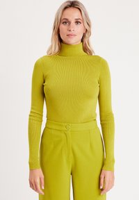 Haut à col roulé côtelé et ajusté en vert lime vif, associé à un pantalon taille haute assorti avec un détail de bouton avant.