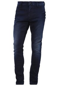 Mörkblå slim-fit jeans med lätt nötning på låren, knäppning med knapp och dragkedja, samt fram- och bakfickor.