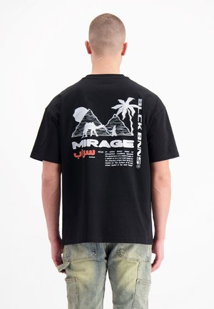 Schwarzes T-Shirt mit einem grafischen Druck auf der Rückseite, das Palmen, Berge und den Text "MIRAGE" in Weiß und Rot auf einem einfarbigen schwarzen Hintergrund zeigt.