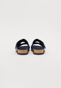 Marine sandaler med to brede remme, korkfodersål og struktureret gummisål. Justerbar spænde detalje på den ene rem for en sikker pasform.
