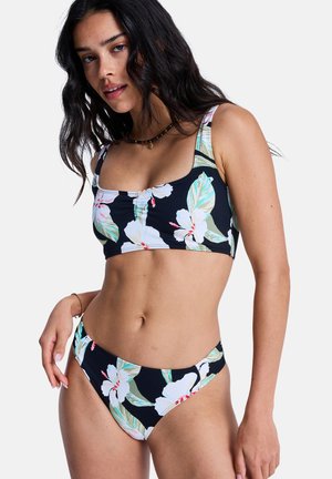 Floral bikini set featuring a black background, large white and green flowers, square neckline, and thin straps with a low-rise bottom.
