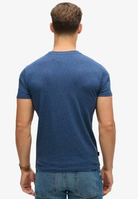 Blauwe heathered crew-neck t-shirt met korte mouwen. Zachte textuur en regular fit. Label aan de linkeronderkant. Eenvoudig ontwerp zonder graphics.