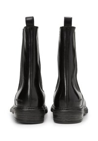 Stivali ankle in pelle nera con finitura liscia, pannelli laterali elasticizzati e tacco basso impilato. Design minimalista con logo del marchio sul tacco.