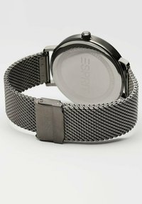 Edelstahlarmbanduhr mit einem Mesh-Armband. Schwarzes rundes Gehäuse, minimalistisches Design und eine sichere Schließe. Die Rückseite zeigt die Marke in klarer Schrift.