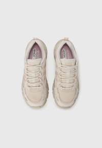 Light beige athletic shoes with mesh and synthetic uppers, textured accents, padded tongue, and rubber outsole. Features pink detailing and laces.