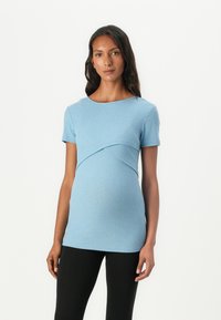 Blå ribbestrikket graviditetstopp med kort erme og buet sømdetalj, komplementert av en tettsittende design og myk tekstur.