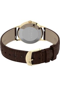 Hodinky z nerezové oceli se zlatým tónem, kulatým ciferníkem, hnědým koženým řemínkem s texturou a lesklou přezkou s názvem značky.