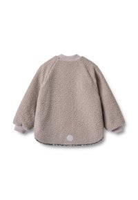 Pūkaina, gaisviela brūna vilnas jaka ar raglāna piedurknēm, ribotām aprocēm un noapaļotu apakšu. Aizmugurē redzams metālisks logo.