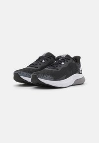 Schwarze Sportschuhe mit einem strukturierten Mesh-Obermaterial, ausgestattet mit weißen Akzenten, Schnürsenkeln und einer leichten, gepolsterten Sohle mit einem gemusterten Griff.