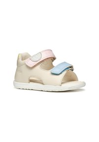 Sandalia de cuero beige con diseño de punta abierta, correas de Velcro en azul y rosa, y suela de goma blanca. Cuenta con perforaciones para transpirabilidad.