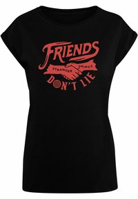 Schwarzes T-Shirt mit lockerer Passform, das ein rot grafisches Design zeigt. Das Design enthält den Text "FRIENDS" und "DON'T LIE" sowie eine Illustration eines Handschlags.