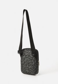 Borsa a tracolla nera con un design grigio a fantasia, tracolla regolabile, forma rettangolare e scomparto con zip sul lato.