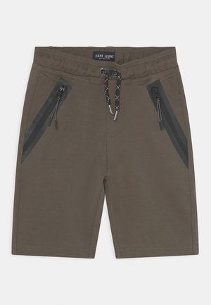 Bruine shorts met een koord in de taille, twee ritszakken aan de zijkanten met zwarte accenten en een gladde stoftextuur.