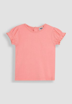 Roosa lühikeste varrukatega T-särk, millel on pehme puuvillane kangas, volangiliste varrukatega ja ümmargune kaelus, tagumiselt nööbiga sulgemiseks.