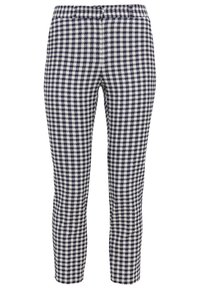 Checked knit pants featuring a navy and white pattern, elastic waistband, tapered shape, and smooth texture. No visible hardware or accents.