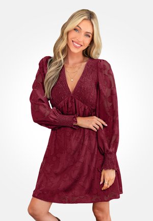 Bordowa sukienka z marszczonym gorsetem i długimi, przejrzystymi rękawami. Posiada głęboki dekolt w kształcie litery V oraz kwiatowy, teksturowany wzór na całej powierzchni.