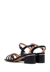 Zwarte hakken sandalen met meerdere kruislings banden, een gesloten achterkant en een mid-hoog blokhak. Gladde leren afwerking, minimale versieringen.