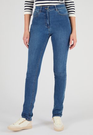 Jeans blu a vita alta con una texture in denim liscia, vestibilità slim e design classico a cinque tasche, abbinati a sneakers bianche.