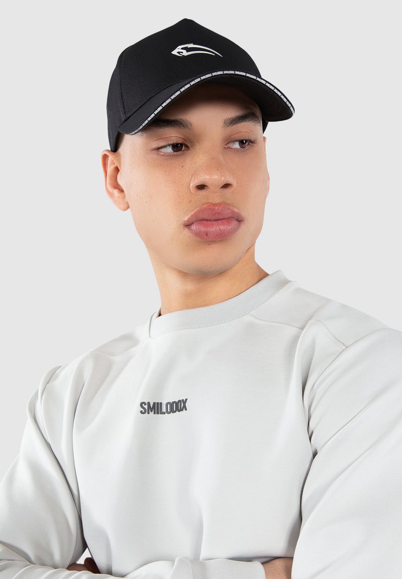 Black cap with a white logo on the front, featuring a stitched visor. Light gray sweatshirt with a black logo on the chest.