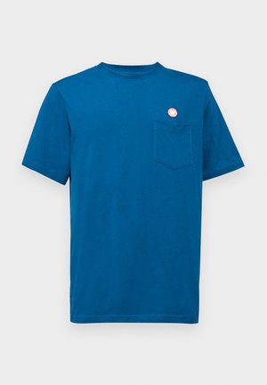 T-shirt en coton bleu avec un col rond, des manches courtes et une petite poche avant. Présente un bouton décoratif rond rose sur la poitrine gauche.