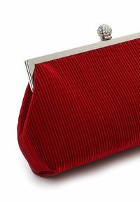 Clutch bag in velluto rosso con texture a righe verticali, cornice in argento e chiusura con calamita impreziosita da cristalli per una chiusura sicura.