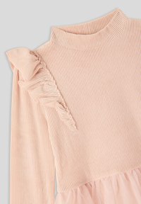 Różowa sukienka z prążkowanej dzianiny z długimi rękawami, z falbaniastym akcentem na jednym ramieniu oraz warstwową, przezroczystą tiulową spódnicą u dołu.