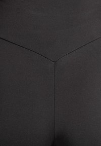 Svarta leggings i slät, stretchig tyg. Har hög midja och en söm mitt fram som ger en åtsittande silhuett.