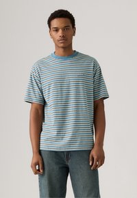 Striped short-sleeve t-shirt in blue, beige, and white; features a round neck and relaxed fit. Material appears soft with a casual design.