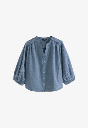 Bluza în carouri alb-albastră, cu șapte nasturi în față, mâneci bufante trei sferturi și decolteu rotund cu decupaj mic în V.