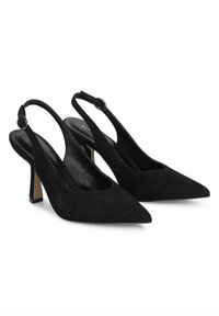 Décolleté in suede neri con punta affusolata, cinturini sottili alla caviglia e tacco a blocco moderato. L'interno presenta una fodera nera a contrasto.