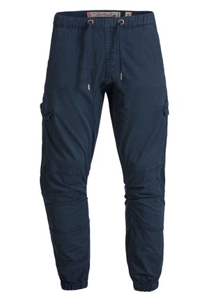 Pantalones cargo azul marino con cintura elástica, cordón y bolsillos laterales. El material es suave con una textura lisa. Puños ajustados en los tobillos.