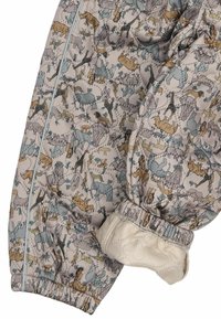 Manche d'une veste matelassée beige avec poignet élastique, ornée d'un imprimé safari multicolore d'animaux comprenant des éléphants, des girafes, des lions et des rhinocéros.